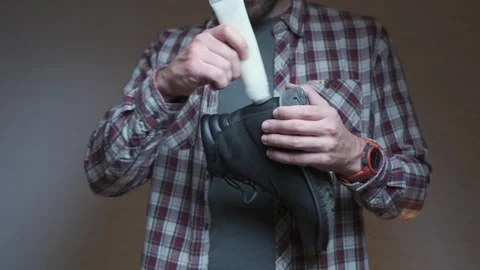 Leather boot maintenance in progress as cream is applied to the surface. The Stock Footage 334212907