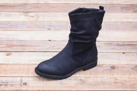 Leather boot at wood background Stock Photos