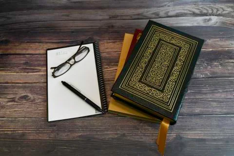 Leather bound books with notebook on rustic wood desk Stock Photos