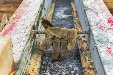 Leather construction gloves on the concrete surface of the foundation. Old wo Foto stock