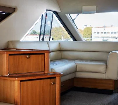 Leather corner sofa inside the boat with a view from the window Stock Photos