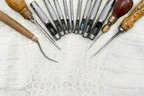 Leather craft tools on a leather background. Craftsman work desk Stock Photos