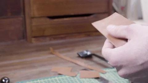 Leather craft workshop, man pierces the skin with a special tool Stock Footage 132341397