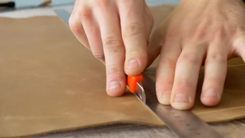 Leather craftsman cutting skin using ruler Stock-Footage 118135056