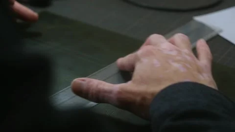 Leather craftsman marking line using ruler and pen Stock Footage 296749011