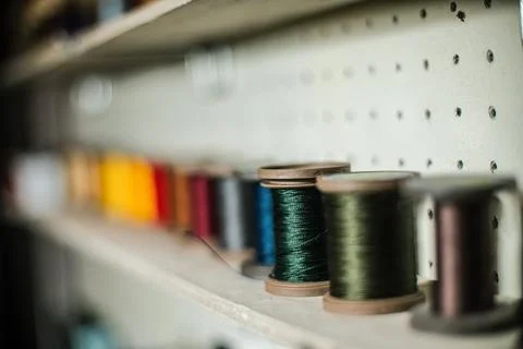 Leather craftsman threads and tools for leather works collected on shelf Stock Photos