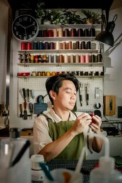 Leather craftsman working in front of tools shelf Stock Photos