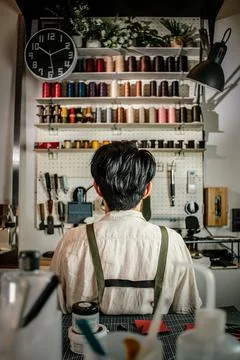 Leather craftsman working in front of tools shelf Stock-Fotos