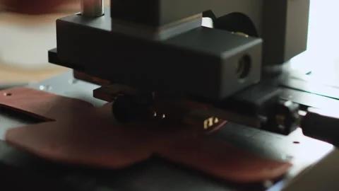 Leather embossing on hot stamping machine close up branding text pressed into Stock Footage 323326416
