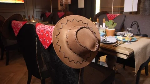 A Leather Hat on the Back of A Chair. A Stylized Party. Candlelit dinner. Stock Footage 151387034