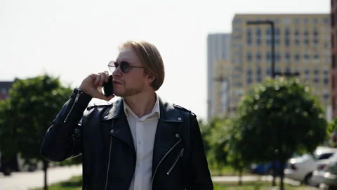 A leather jacket from a confident young man. A man listens to a telephone Stock Footage 247053874