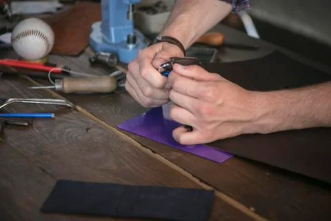 Leather maker cut leather with utility knife on wooden working table Stock Photos