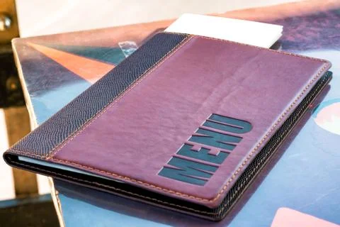 A leather menu pad resting on a table, with blank sheets at the top ready for Stock Photos