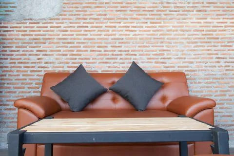 Leather orange sofa with brick wall brown background Stock Photos