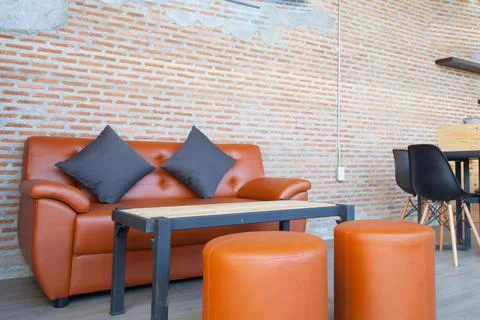 Leather orange sofa with brick wall brown background Stock Photos