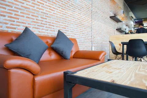 Leather orange sofa with brick wall brown background Stock Photos