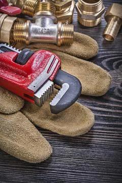 Leather protective gloves monkey wrench brass plumbing fittings ball valve on 库存照片