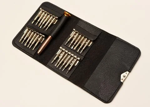 A leather purse with a screwdriver and bits. A set of different screwdrivers. Stock Photos