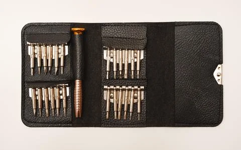 A leather purse with a screwdriver and bits. A set of different screwdrivers. Stock Photos