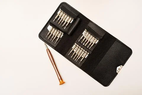 A leather purse with a screwdriver and bits. A set of different screwdrivers. Stock Photos