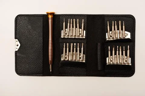 A leather purse with a screwdriver and bits. A set of different screwdrivers. Stock Photos