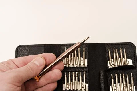 A leather purse with a screwdriver and bits. A set of different screwdrivers. Stock Photos