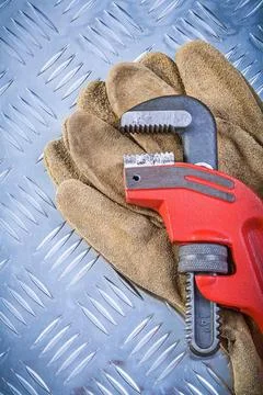 Leather safety gloves Monkey spanner on corrugated sheet metal Construction 库存照片