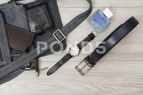 Leather shoulder bag for men with mobile phone and wristwatch on gray backgro Stock Photos