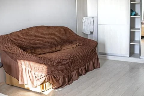 Leather sofa with a brown throw in the room near the wardrobe with mirrors Stock Photos