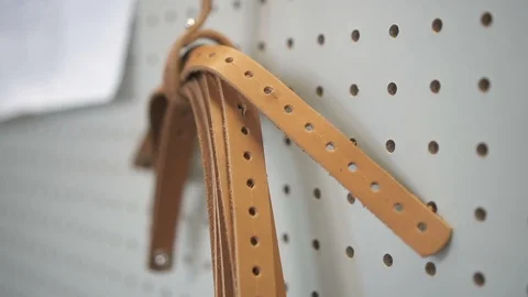 Leather strap hanging in workplace. stack of leather belt material. concept Stock Footage 121389763
