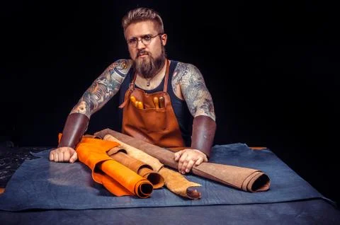 Leather Tanner working with leather using crafting tools at his desk Foto stock