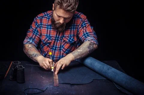 Leather Tanner working with leather using crafting tools at workplace Foto stock