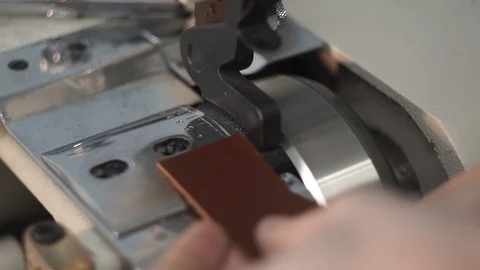 Leather thinning with a machine. A tanner pats a leather blank. Close-up. Video stock 104925727