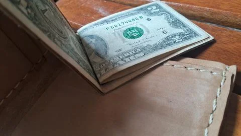 Leather wallet with dollar bills inside. Business and financial concept image. Stock Photos