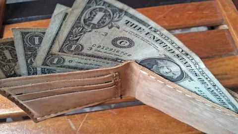 Leather wallet with dollar bills inside. Business and financial concept image. Stock Photos