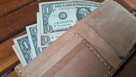 Leather wallet with dollar bills inside. Businessman holding cash for financial Stock Photos