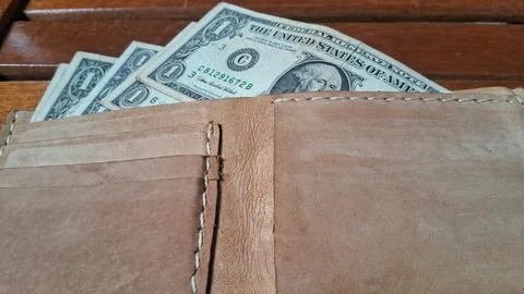 Leather wallet with dollar bills inside. Business and financial concept image. Stock Photos