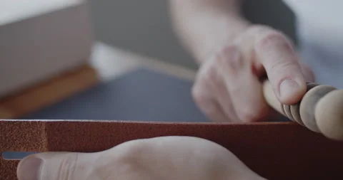 Leather worker burnishing edge of a leather belt during manufacturing process Stock Footage 144893732
