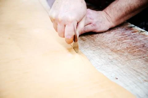 Leather worker cutting leather Stock Photos