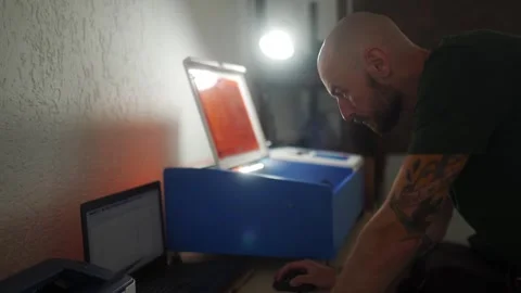 Leather worker designes new product in programme on laptop in workshop. Handsome Stock Footage 256295908