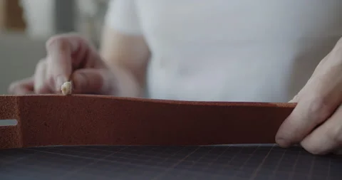 Leather worker dyeing edge of a leather belt during manufacturing process Stock Footage 144893423