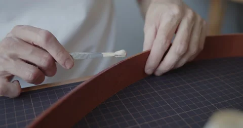Leather worker dyeing edge of a leather belt during manufacturing process Stock Footage 146136284