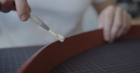 Leather worker dyeing edge of a leather belt during manufacturing process Stock Footage 146136419