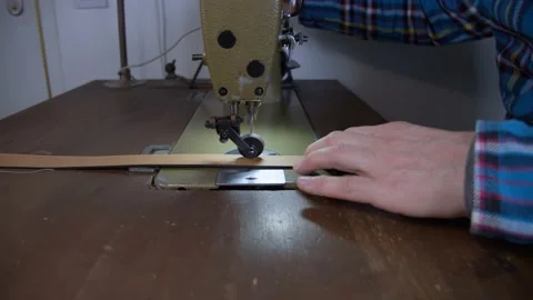 The leather worker or craftsman sewing the orange leather belt Stock Footage 152185488