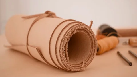 Leather working tools and rolled up hide organized Stock Footage 126115456