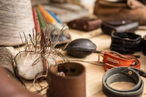 Leather working tools on working desk, bunch of needles, shallow dof Stock Photos