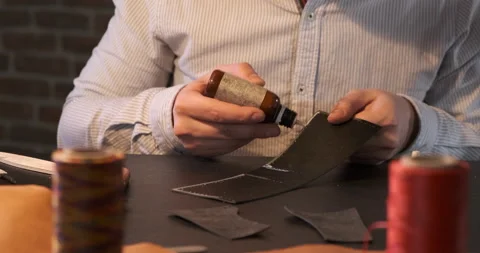 Leatherworker Master Applies Glue to Leather blank, Small Home Office Production Stock Footage 133008366