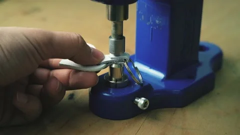 A leatherworker uses a press to set a metal rivet on a genuine leather product Stock Footage 158037751
