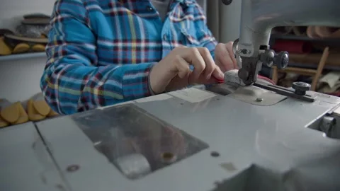 The leatherworker's hands process or skive the edge of a piece of leather Stock Footage 152185427