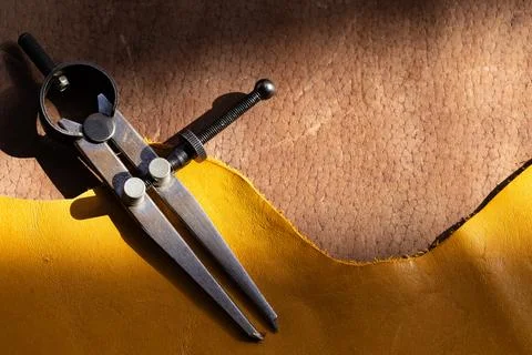 Leatherworking tools, compass and materials for artisanal design. Stock Photos